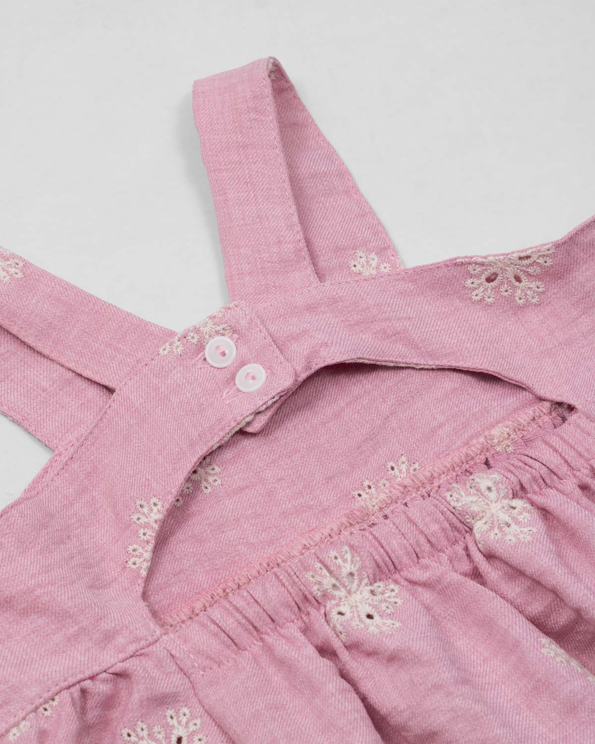 Vestido de tiras en lino rosado con flores y botonadura en espalda para niña