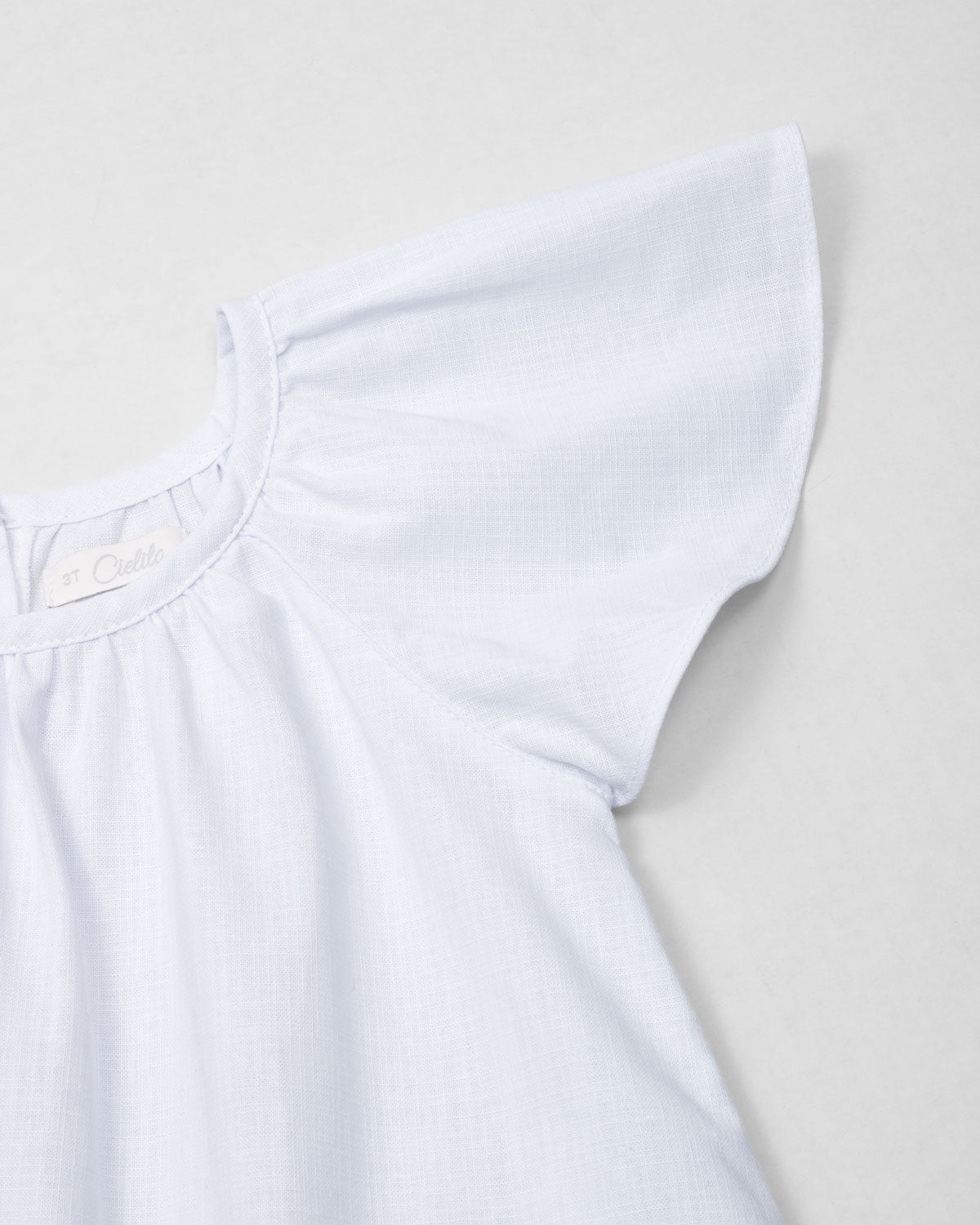 Vestido en lino blanco con estampado de flores para niña