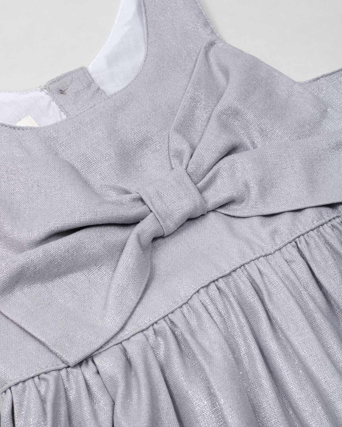 Vestido plateado en lino con brillos, moño y botones en espalda para niña