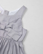 Vestido plateado en lino con brillos, moño y botones en espalda para niña