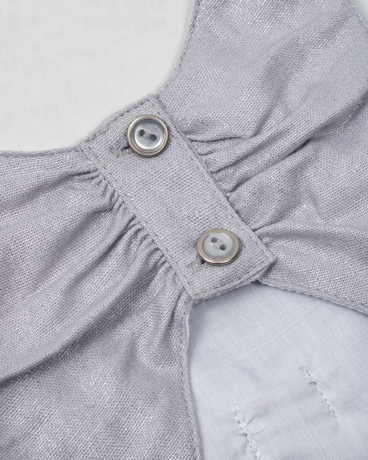 Vestido plateado en lino con brillos, moño y botones en espalda para niña