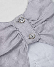 Vestido plateado en lino con brillos, moño y botones en espalda para niña