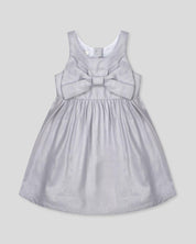Vestido plateado en lino con brillos, moño y botones en espalda para niña