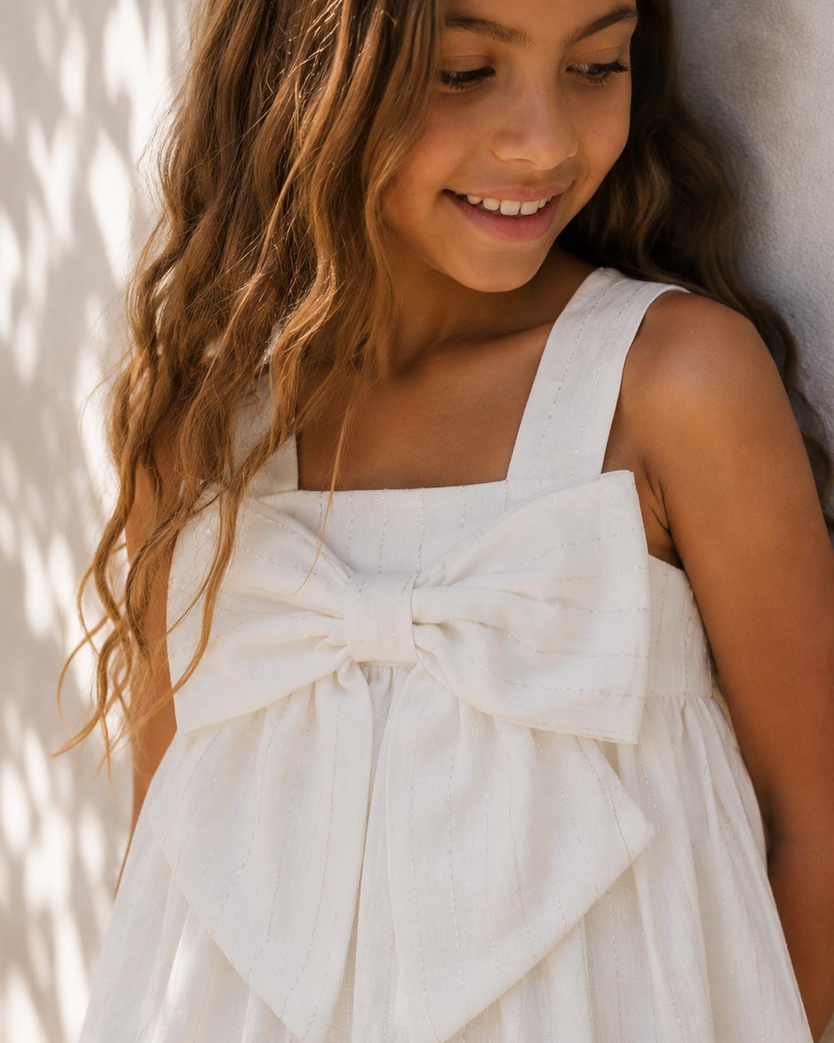Vestido blanco con moño y líneas plateadas para niña