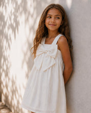 Vestido blanco con moño y líneas plateadas para niña