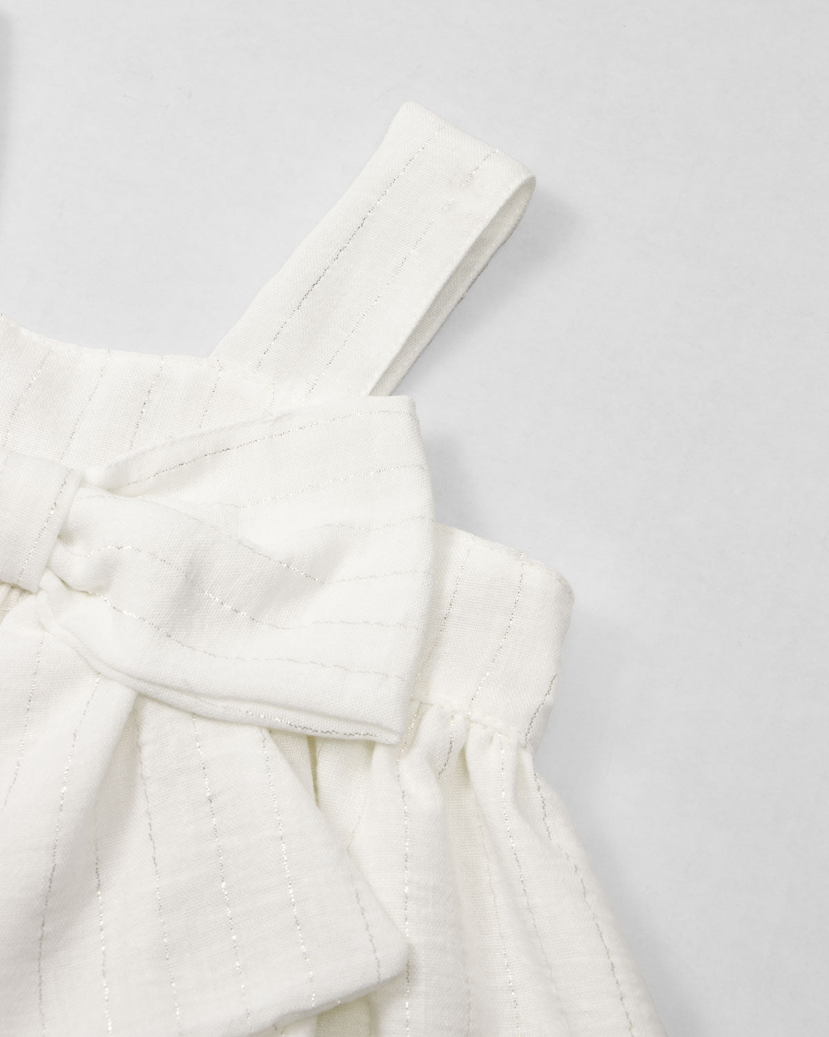 Vestido blanco con moño y líneas plateadas para niña