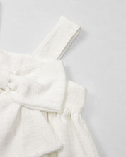 Vestido blanco con moño y líneas plateadas para niña