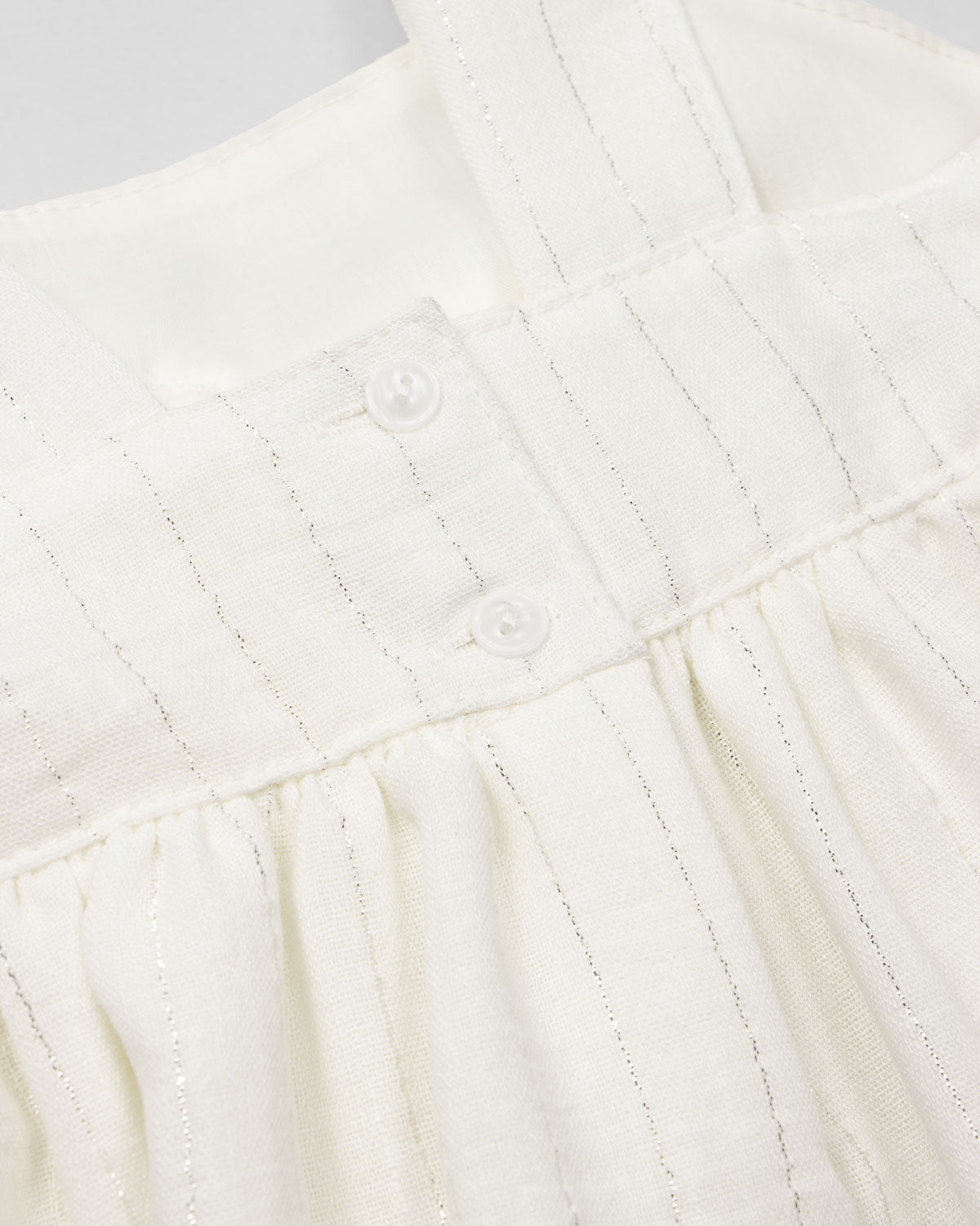 Vestido blanco con moño y líneas plateadas para niña