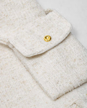 Vestido blanco terminado en bolero con tejido texturizado y bolsito pequeño para niña