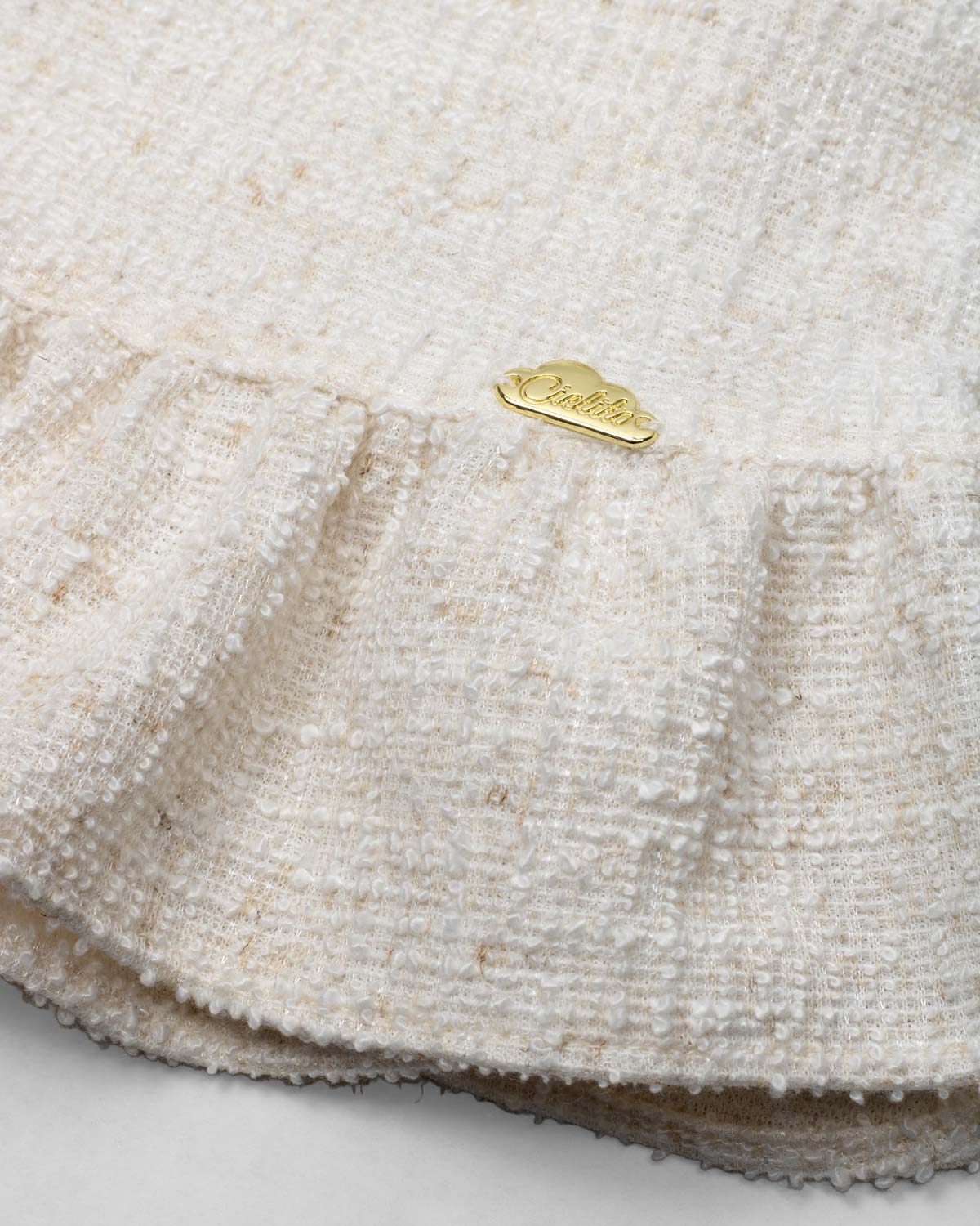 Vestido blanco terminado en bolero con tejido texturizado y bolsito pequeño para niña