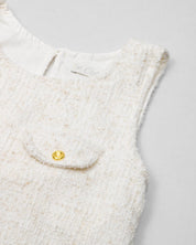 Vestido blanco terminado en bolero con tejido texturizado y bolsito pequeño para niña