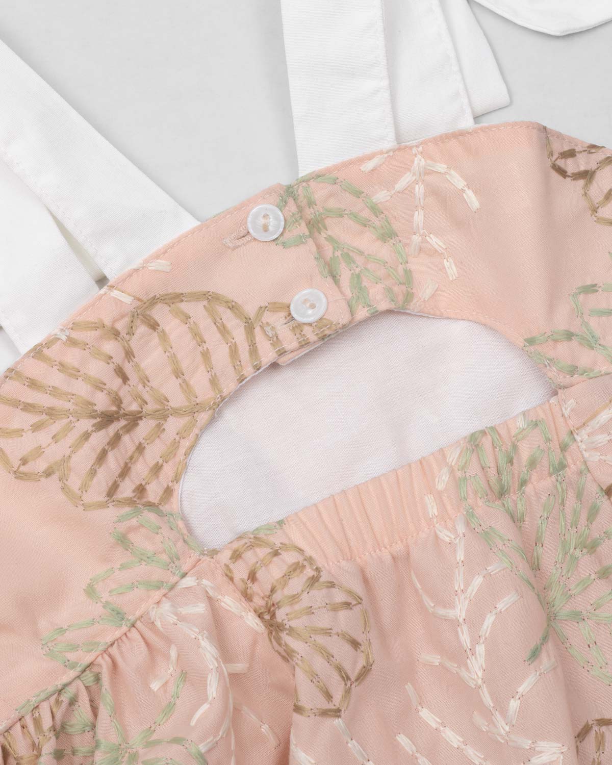 Vestido café con bordado de hojas y tiras blancas con moño para niña