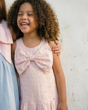 Vestido en tela hoja rota rosa con flores y moño para niña