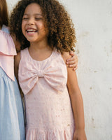 Vestido en tela hoja rota rosa con flores y moño para niña