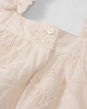 Vestido crema de tiras zurcidas con tela con bordado de flores y lentejuelas para niña
