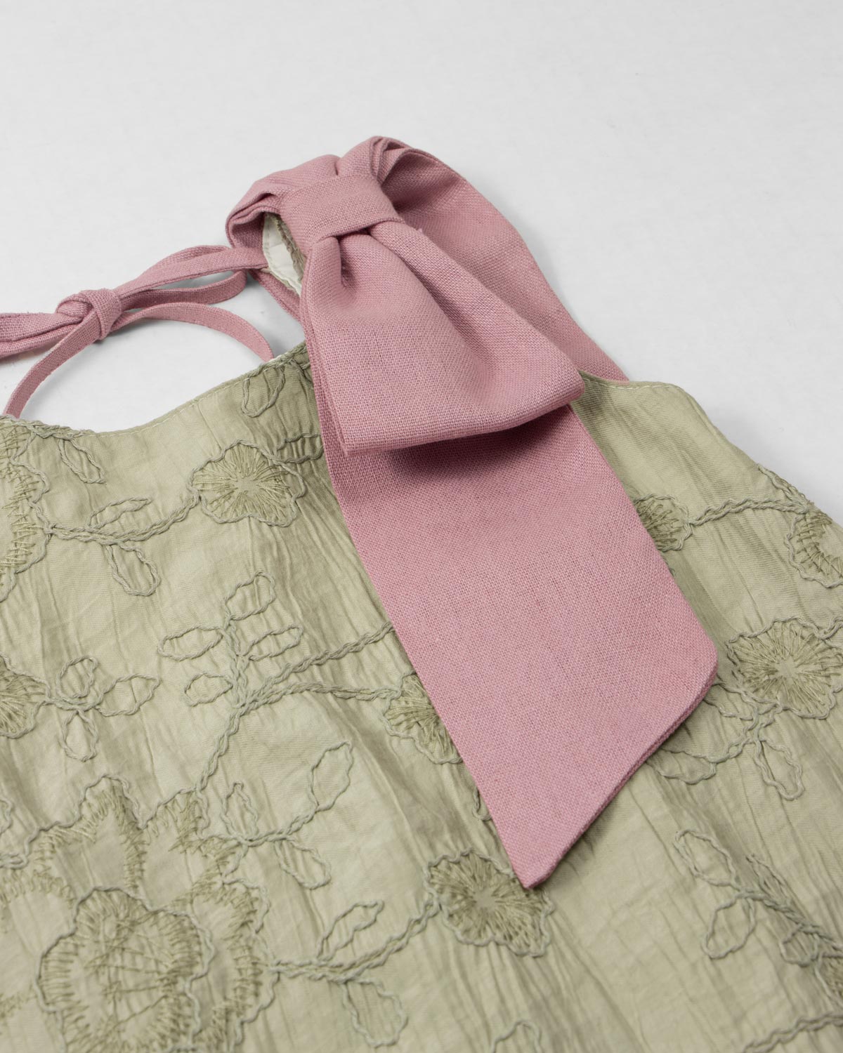 Vestido verde con flores bordadas y moño rosa en hombro para niña
