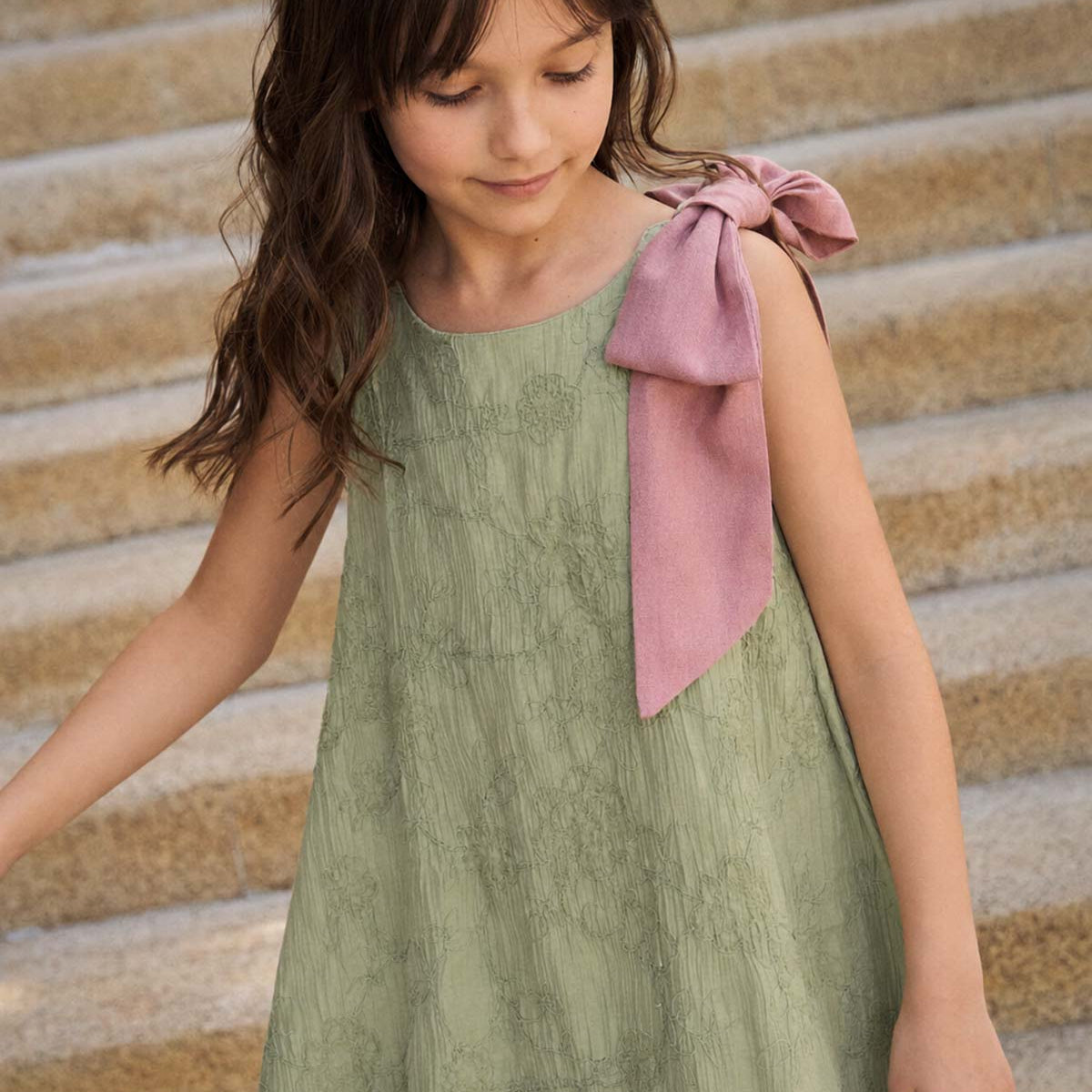 Vestido verde con flores bordadas y moño rosa en hombro para niña