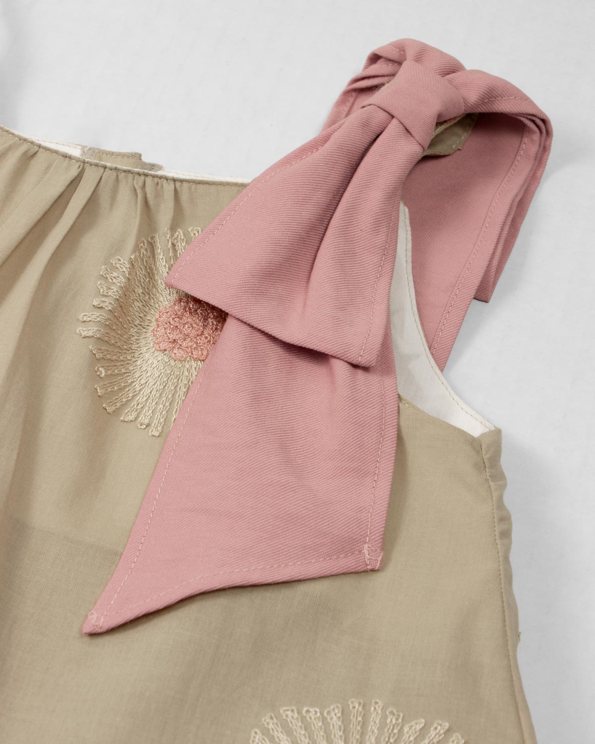 Vestido café de tiras con bordados de flores y moño rosa en hombro para niña