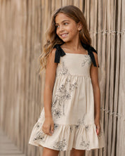 Vestido crema con diseño de flores tejido y tiras con moño para niña