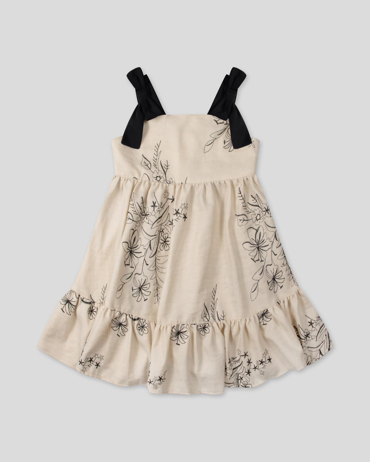 Vestido crema con diseño de flores tejido y tiras con moño para niña