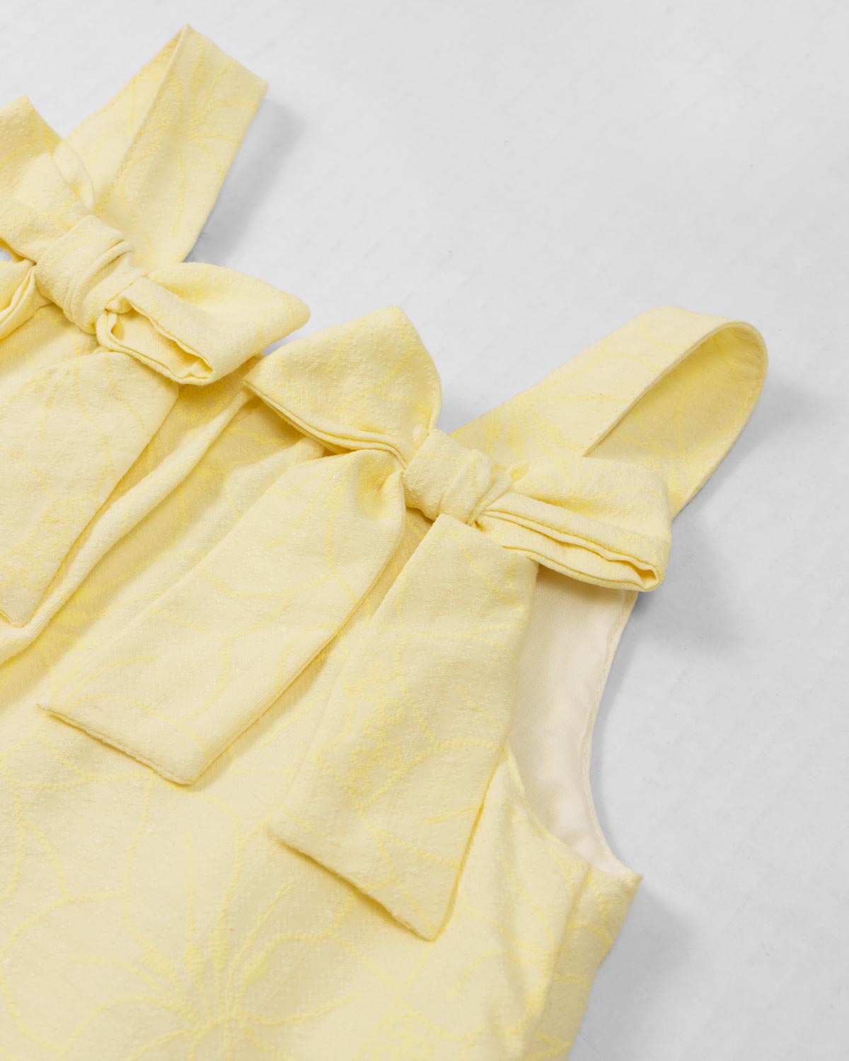 Vestido amarillo con moños y estampado floral para niña