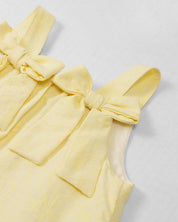 Vestido amarillo con moños y estampado floral para niña