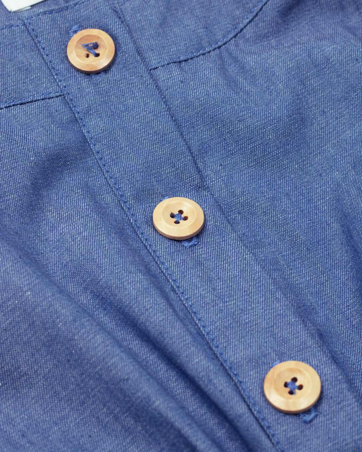 Enterizo corto en chambray con botones y detalle de cinturón verde para niña