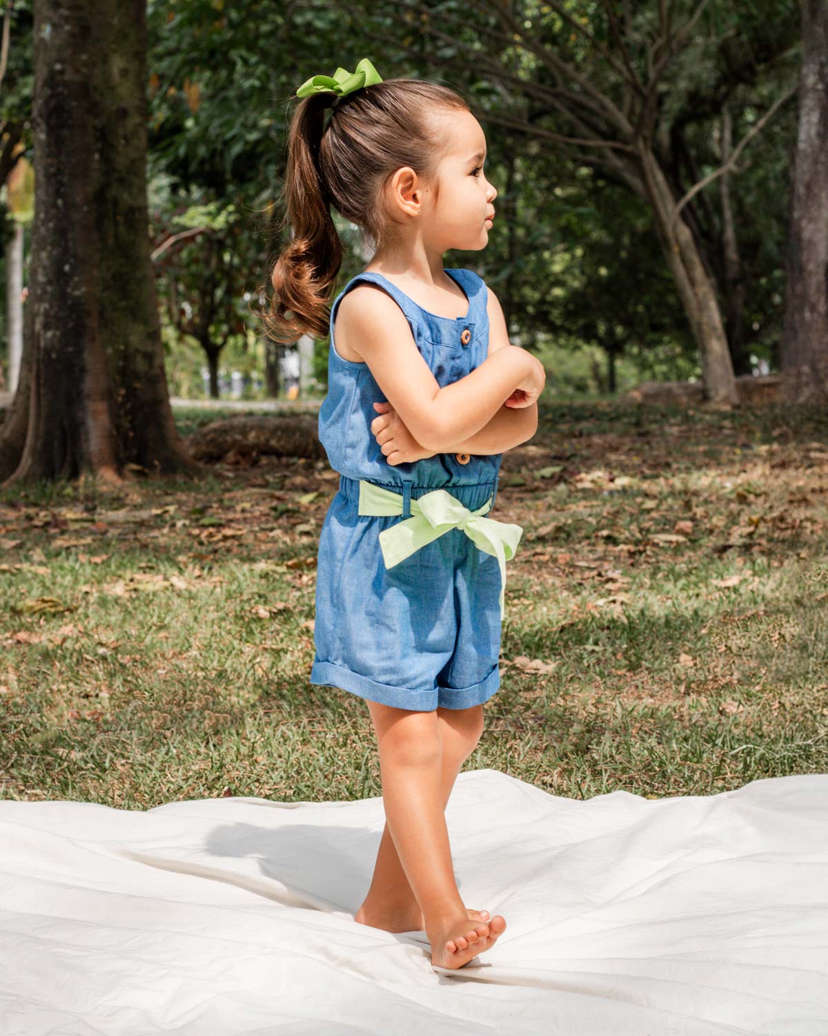 Enterizo corto en chambray con botones y detalle de cinturón verde para niña