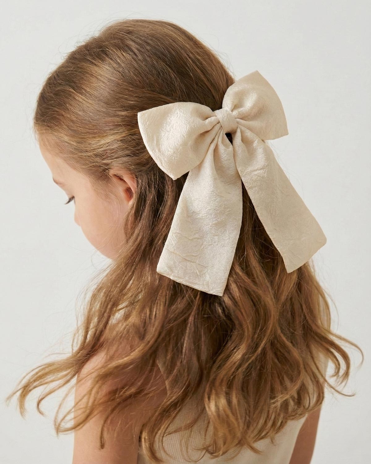 Moño pinza en seda amarillo crema para niña