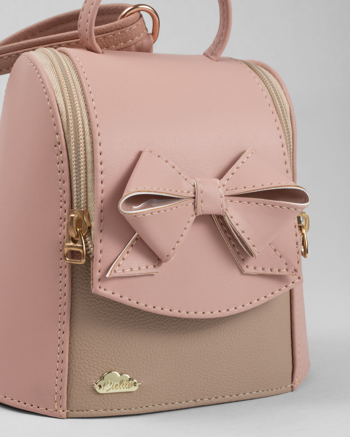 Bolso tipo mochila rosa con detalle de moño y cierre para niña