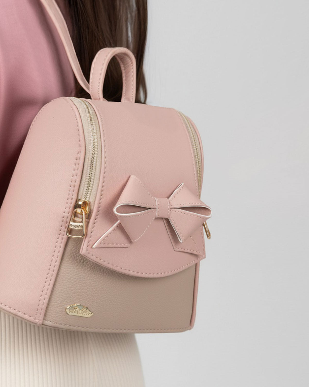 Bolso tipo mochila rosa con detalle de moño y cierre para niña