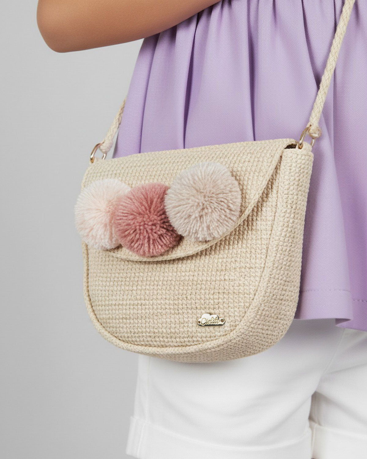 Bolso tejido con pompones y botón de imán para niña