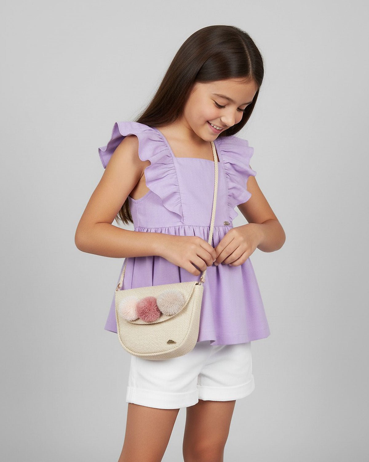 Bolso tejido con pompones y botón de imán para niña