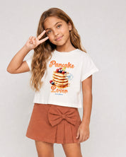Conjunto blusa blanca con estampado Pancake y falda short con moño para niña