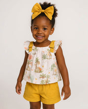 Total look de conjunto mostaza con moño pinza para niña.