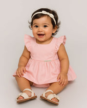 Total look de vestido rosa, balacas y sandalias para bebé niña.