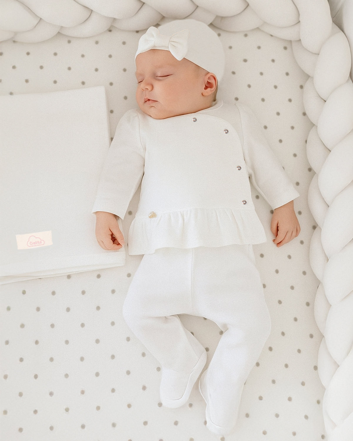 Ajuar blanco de dos piezas, gorrito y cobija para recién nacida.