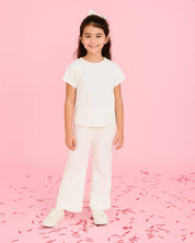 Conjunto blusa y pantalón blancos en tejido texturizado para niña