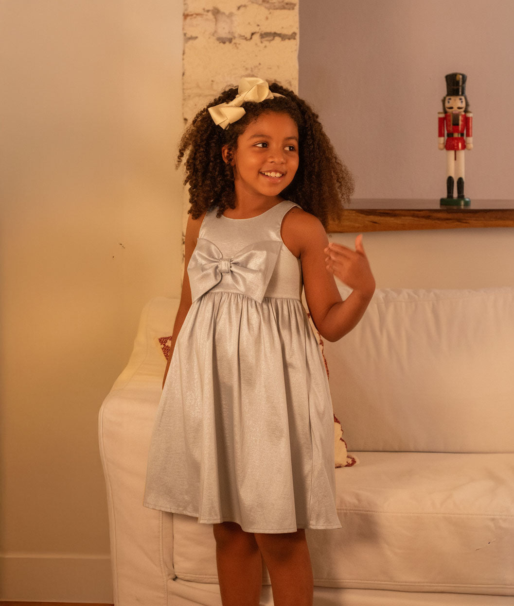 Vestido plateado en lino con brillos, moño y botones en espalda para niña