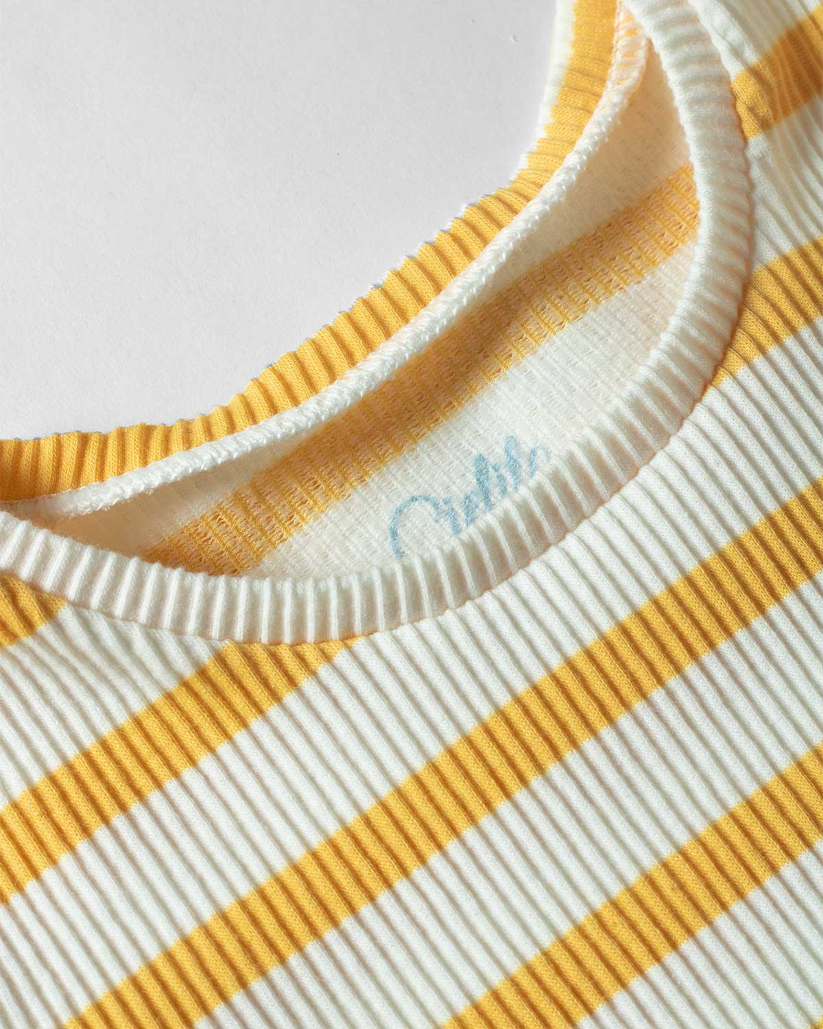 Camiseta beige con línea mostaza y bolero en mangas para niña