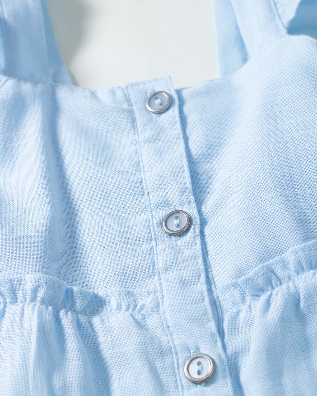 Vestido azul de tiras con boleros y botonadura para niña